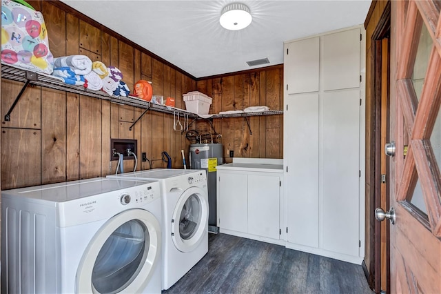 6501 62nd St N, Pinellas Park, FL 33781 - laundry area with dark wood-style flooring, wood walls, water heater, cabinet space, and washer and clothes dryer