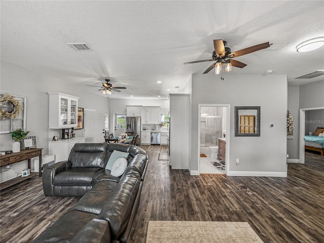 living area with visible vents, baseboards, wood finished floors, a textured ceiling, and a ceiling fan