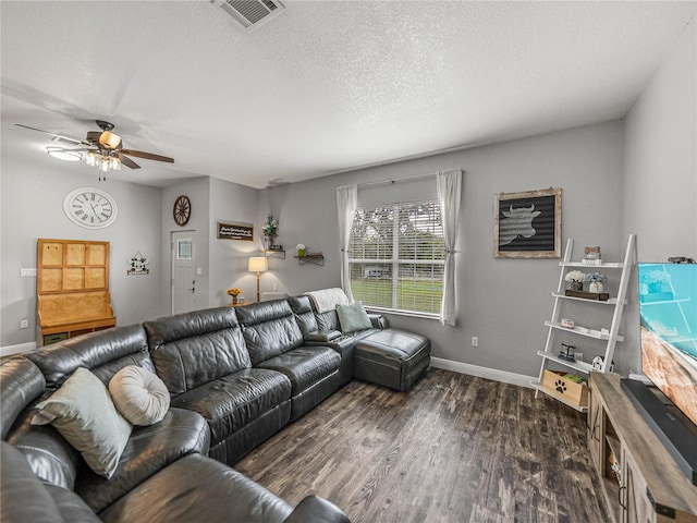 living area featuring a ceiling fan, baseboards, visible vents, dark wood-style flooring, and a textured ceiling