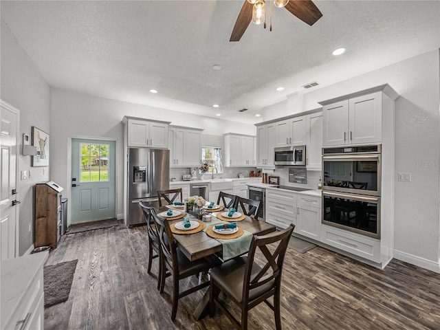 dining room with beverage cooler, visible vents, ceiling fan, dark wood-type flooring, and a textured ceiling