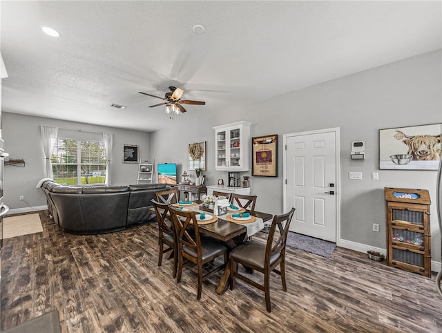 dining room featuring dark wood-style floors, a ceiling fan, and baseboards