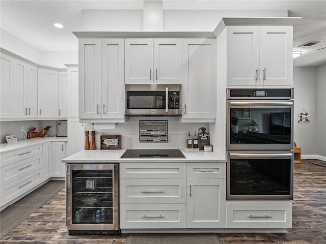 kitchen featuring white cabinetry, beverage cooler, and stainless steel appliances