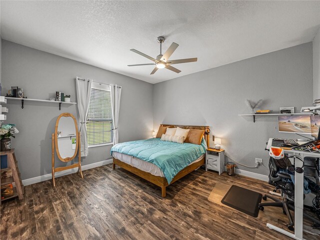 bedroom featuring wood finished floors, baseboards, and a textured ceiling