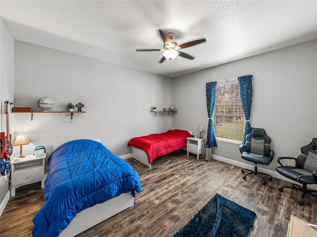 bedroom with wood finished floors, baseboards, and a textured ceiling