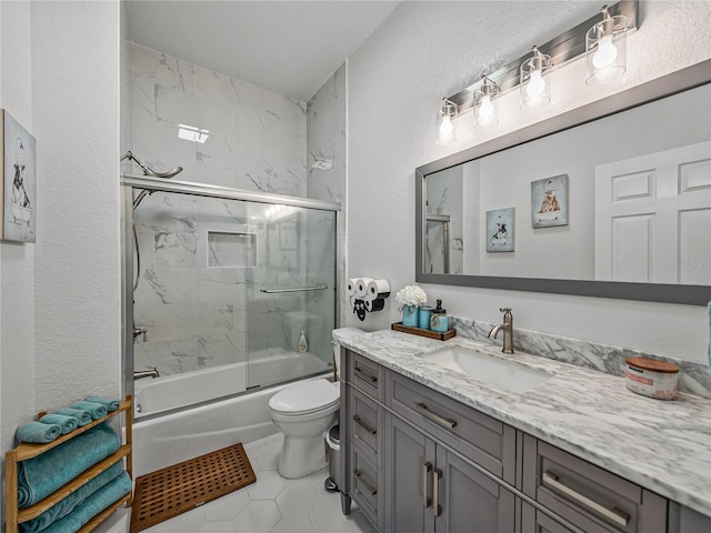 full bath featuring toilet, shower / bath combination with glass door, tile patterned flooring, vanity, and a textured wall