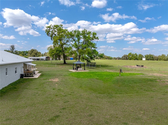 view of yard with a trampoline and a rural view