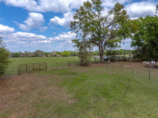 view of yard with a rural view and fence