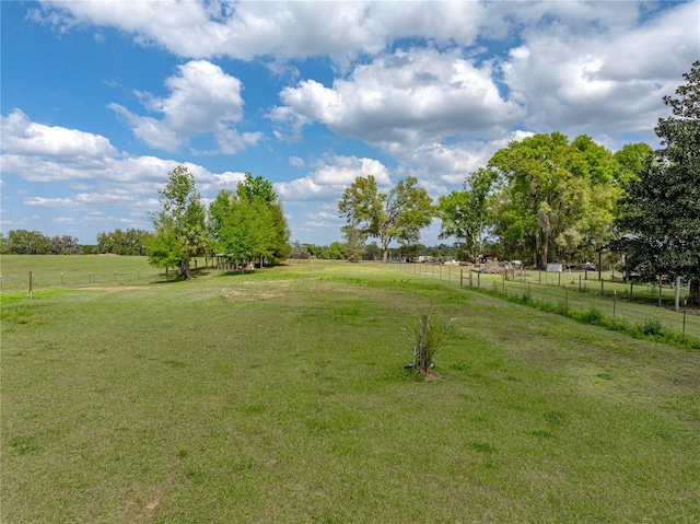 view of yard with a rural view and fence