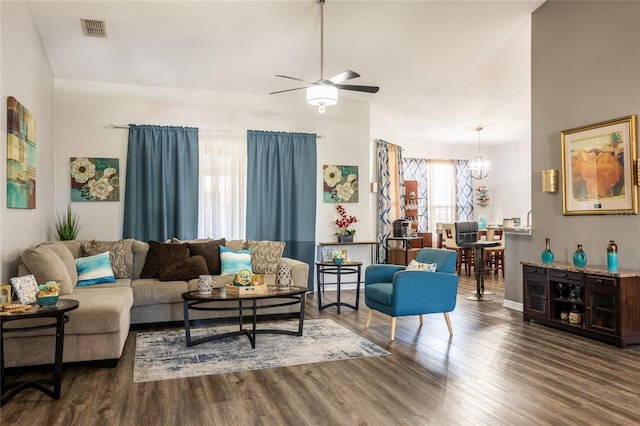 living area featuring visible vents, wood finished floors, and ceiling fan with notable chandelier