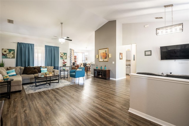 living room featuring visible vents, baseboards, ceiling fan, and dark wood-style flooring