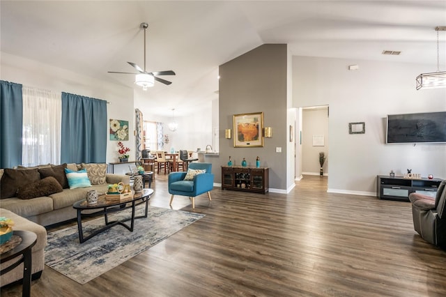 living area with wood finished floors, baseboards, visible vents, high vaulted ceiling, and ceiling fan with notable chandelier