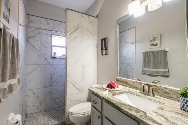 bathroom with a marble finish shower, toilet, and vanity