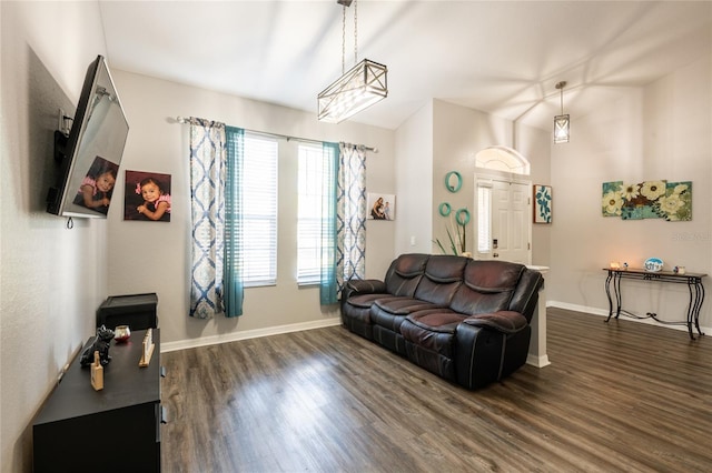 living room with baseboards, dark wood finished floors, and vaulted ceiling