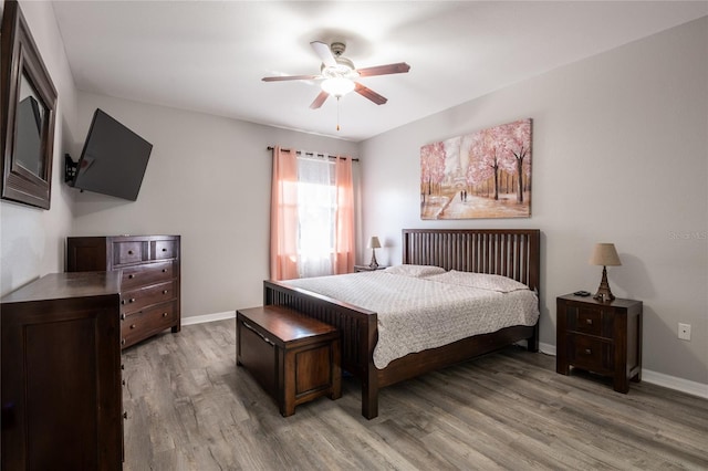 bedroom with light wood-style flooring, baseboards, and ceiling fan