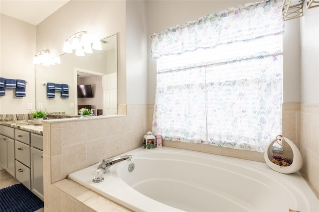 bathroom with a healthy amount of sunlight, a bath, and vanity