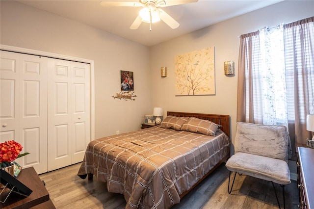 bedroom with a ceiling fan, wood finished floors, and a closet