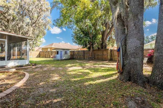 5416 Oxford Manor Cir, Lakeland, FL 33810 - view of yard with a storage unit, an outbuilding, a fenced backyard, and a sunroom