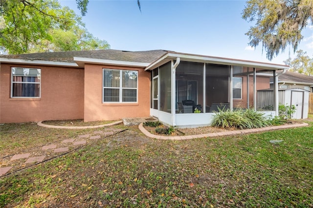 5416 Oxford Manor Cir, Lakeland, FL 33810 - rear view of property with an outbuilding, a sunroom, a shingled roof, stucco siding, and a lawn
