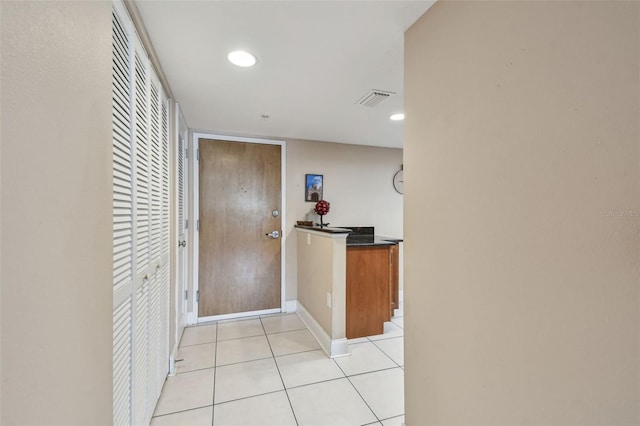 corridor with light tile patterned floors, visible vents, baseboards, and recessed lighting