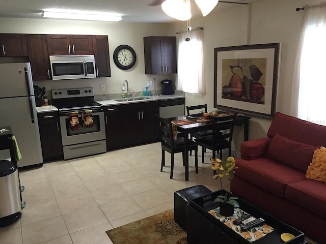 kitchen with a healthy amount of sunlight, light countertops, stainless steel appliances, a ceiling fan, and a sink