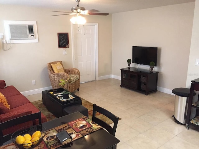 living room featuring an AC wall unit, light tile patterned flooring, a ceiling fan, and baseboards