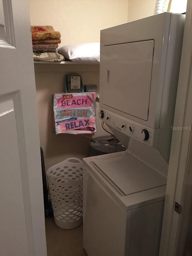 washroom with stacked washer and clothes dryer and laundry area