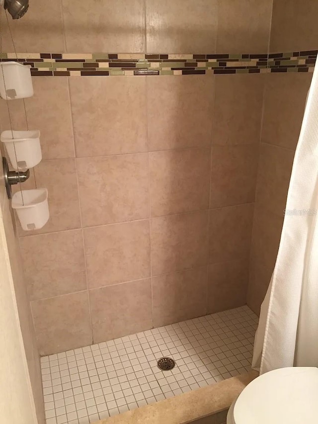 bathroom featuring toilet and a stall shower