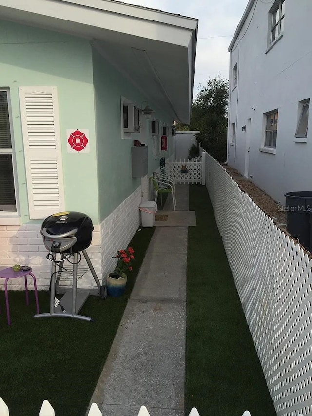 view of side of property with fence and brick siding