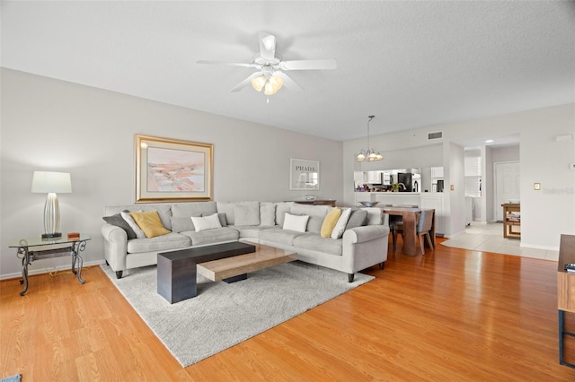1200 Country Club Dr Unit 3303, Largo, FL 33771 - living room featuring ceiling fan with notable chandelier, light wood finished floors, and visible vents