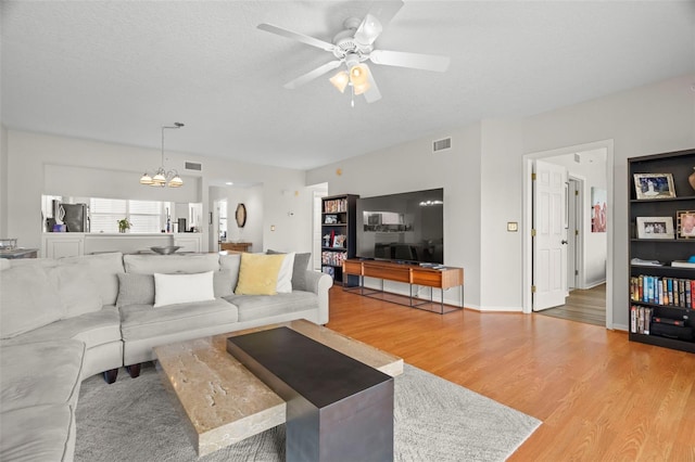 1200 Country Club Dr Unit 3303, Largo, FL 33771 - living area with a textured ceiling, wood finished floors, ceiling fan with notable chandelier, and visible vents