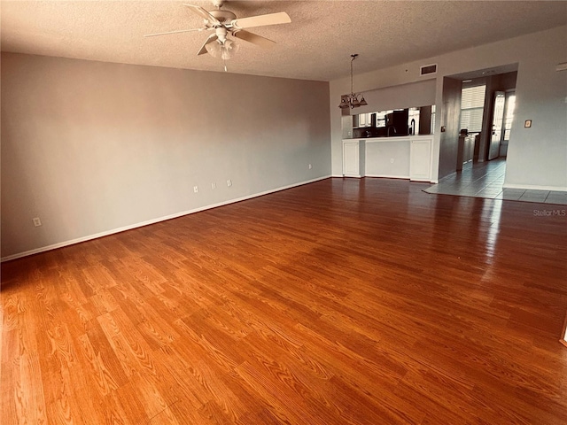 1200 Country Club Dr Unit 3303, Largo, FL 33771 - empty room with wood finished floors, a textured ceiling, ceiling fan with notable chandelier, baseboards, and visible vents