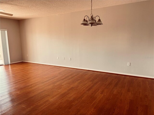 1200 Country Club Dr Unit 3303, Largo, FL 33771 - spare room with dark wood finished floors, a textured ceiling, baseboards, and a notable chandelier