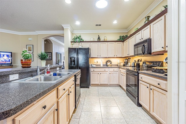 kitchen with visible vents, crown molding, arched walkways, black appliances, and a sink