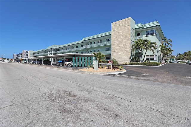 view of property with covered and uncovered parking