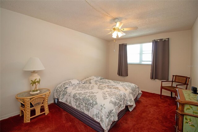 carpeted bedroom featuring baseboards, a textured ceiling, and a ceiling fan