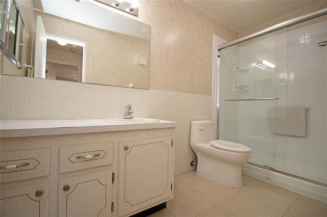 full bathroom with toilet, tile walls, a shower stall, and tile patterned flooring