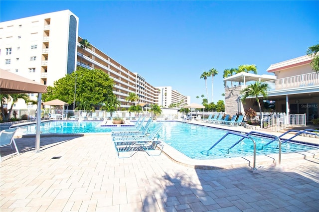 community pool with a patio and fence