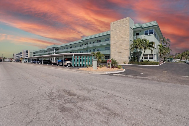 property at dusk featuring covered parking