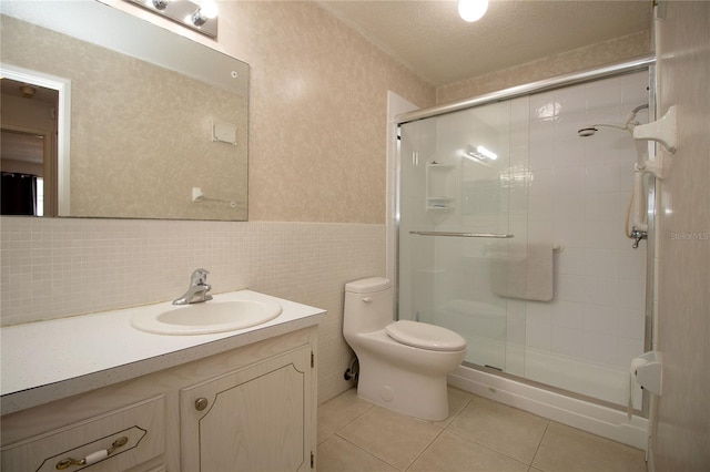 bathroom with tile patterned floors, vanity, toilet, and a shower stall