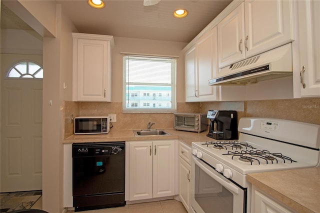 kitchen featuring white gas range oven, light countertops, a sink, under cabinet range hood, and black dishwasher