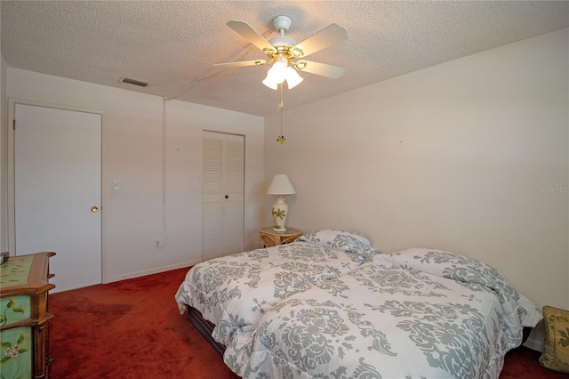 carpeted bedroom with a closet, a textured ceiling, visible vents, and ceiling fan