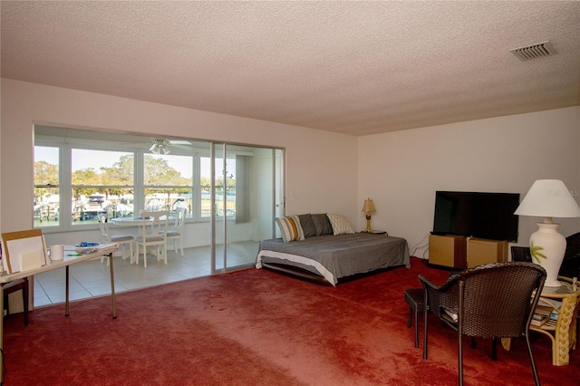 carpeted bedroom with a textured ceiling, visible vents, and tile patterned floors