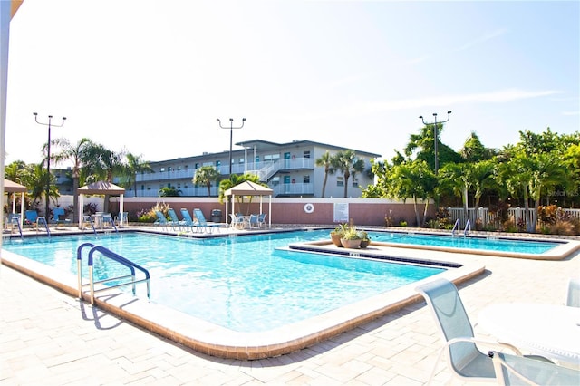 pool with a patio and fence