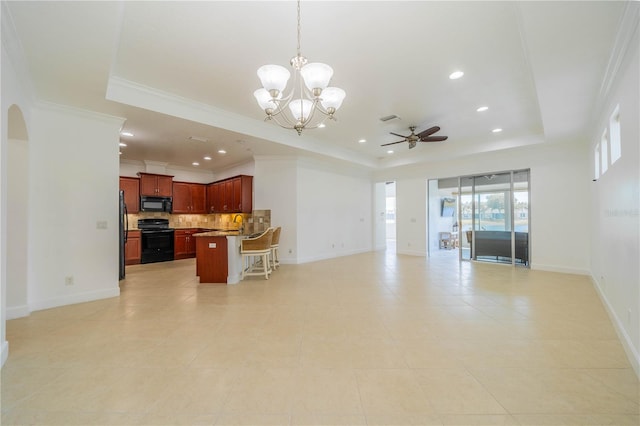 2234 Nottingham Greens Dr Unit 2234, Sun City Center, FL 33573 - living room with baseboards, a tray ceiling, ornamental molding, ceiling fan with notable chandelier, and arched walkways