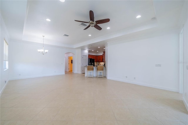2234 Nottingham Greens Dr Unit 2234, Sun City Center, FL 33573 - unfurnished living room with visible vents, a tray ceiling, ornamental molding, ceiling fan with notable chandelier, and arched walkways