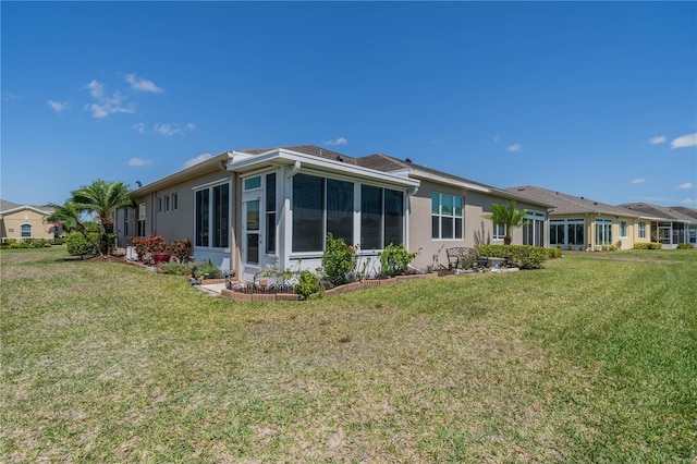 2234 Nottingham Greens Dr Unit 2234, Sun City Center, FL 33573 - rear view of property with stucco siding, a yard, and a sunroom