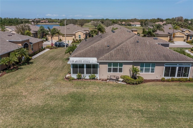 2234 Nottingham Greens Dr Unit 2234, Sun City Center, FL 33573 - rear view of property with stucco siding, a residential view, a yard, and roof with shingles