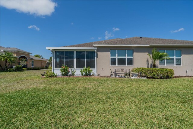 2234 Nottingham Greens Dr Unit 2234, Sun City Center, FL 33573 - rear view of house with a yard, a sunroom, and stucco siding