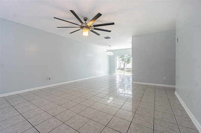 spare room with visible vents, baseboards, ceiling fan, light tile patterned floors, and a textured ceiling