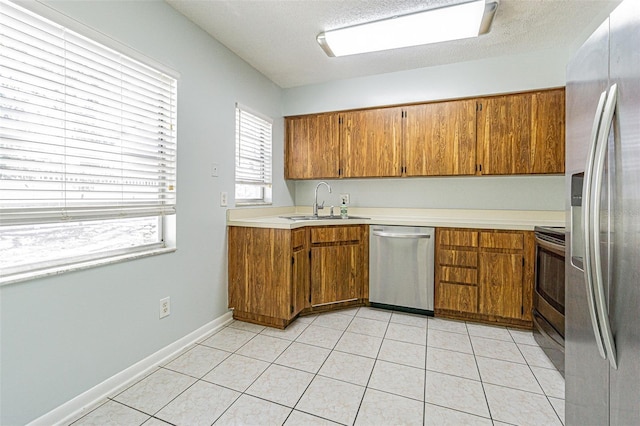 kitchen featuring a sink, appliances with stainless steel finishes, and brown cabinetry